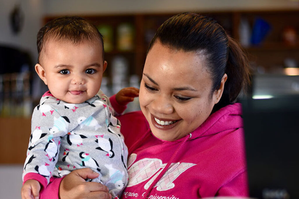 woman holding baby while studying