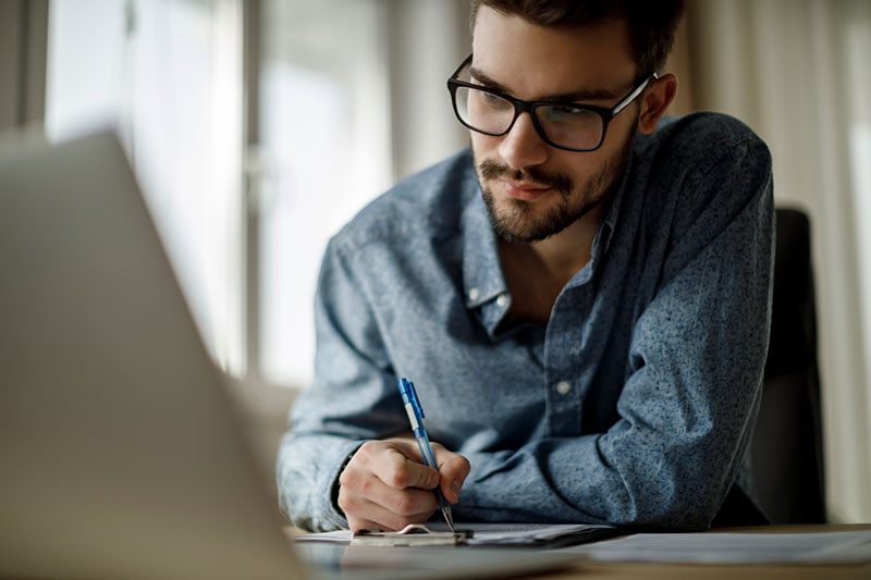 MBA student at desk taking notes