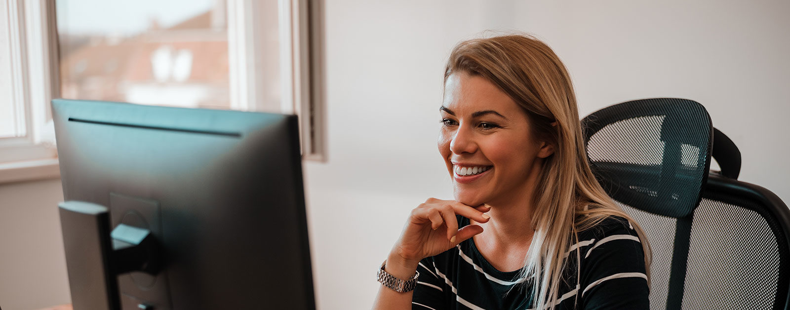 woman smiling at laptop screen