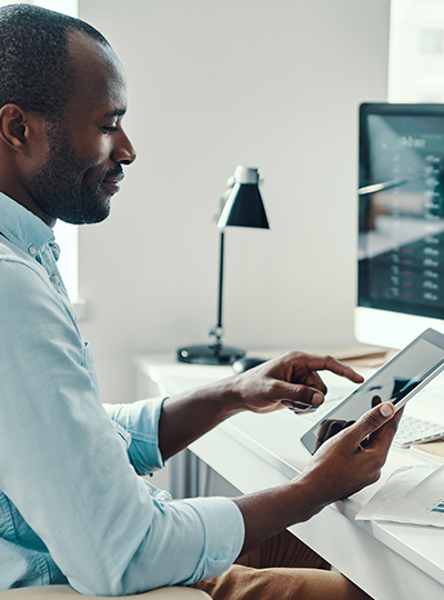 man at desk looking at tablet