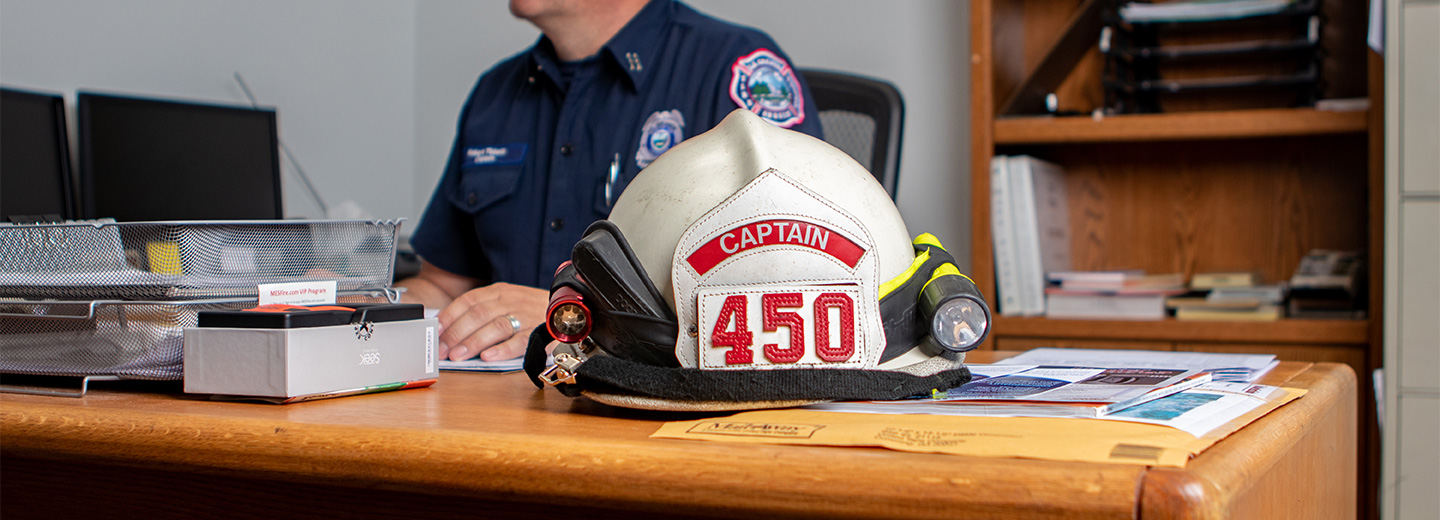 fire captain at desk with hat on corner