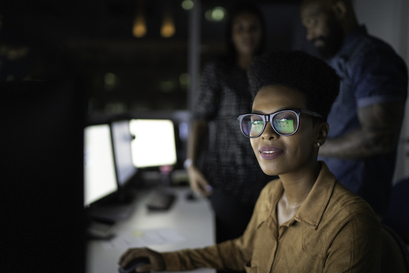 Cybersecurity student in front of monitor at desk