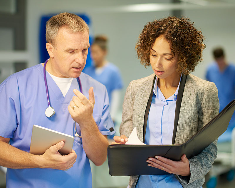 Healthcare administrator speaking with doctor