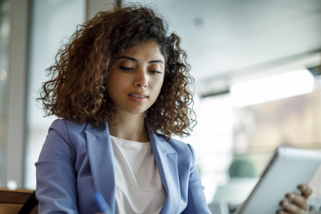 Young professional graduate reviewing content on a tablet in a modern office