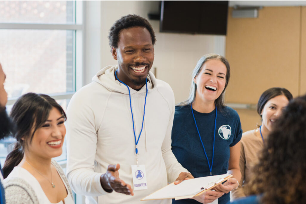 Group of social work volunteers laughing and collaborating during a community outreach program